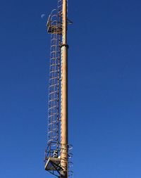 Low angle view of ferris wheel against clear blue sky