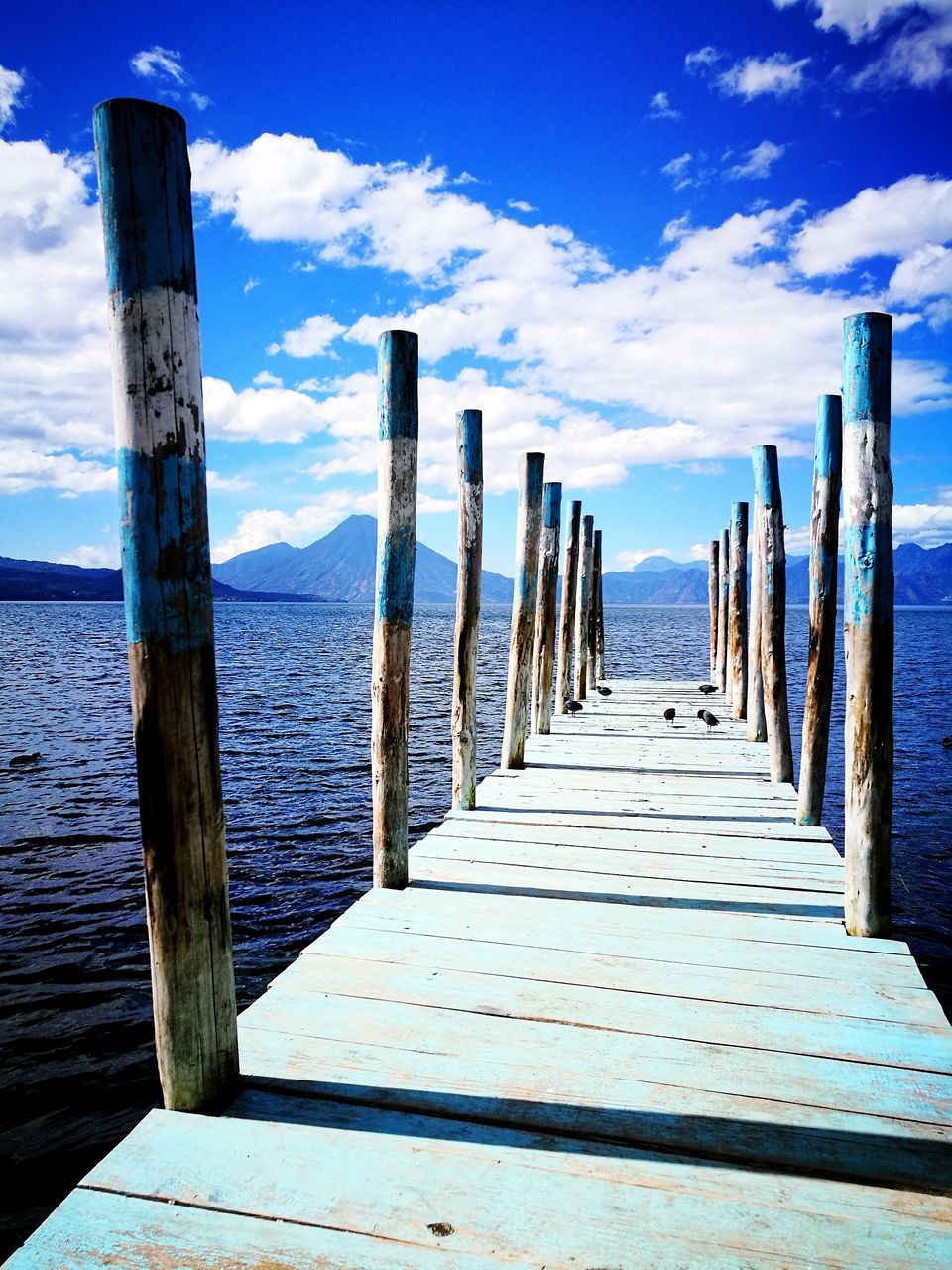 sea, wood - material, water, pier, sky, cloud - sky, nature, tranquility, horizon over water, day, outdoors, no people, jetty, wood paneling, beach, scenics, sunlight, tranquil scene, beauty in nature, blue, wooden post
