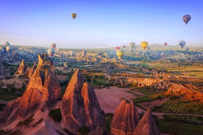 Hot air balloons flying over rock formations at cappadocia