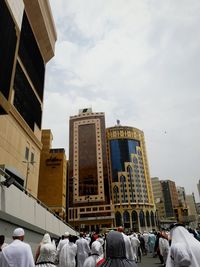 People in front of buildings against sky