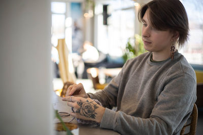 Portrait of young woman sitting at home