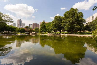 Scenic view of lake by buildings against sky