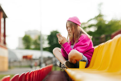 Side view of young woman sitting on chair