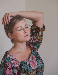 Portrait of woman standing against wall