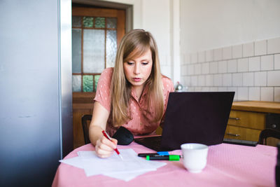 Woman drawing on paper at home