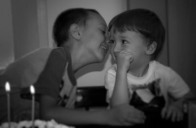 Close-up of brothers sitting at home during birthday