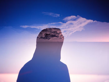 Rear view of woman by sea against sky during sunset