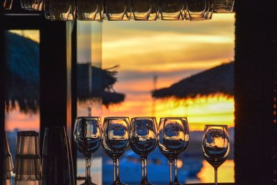 Glass of wine on table against sunset sky
