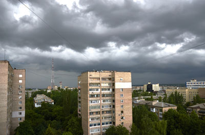 Buildings in city against cloudy sky