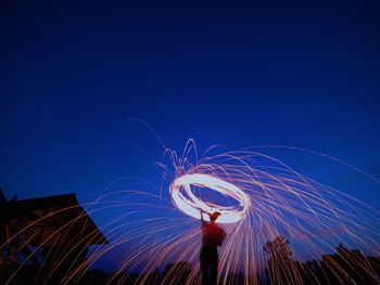 Low angle view of fireworks against sky at night