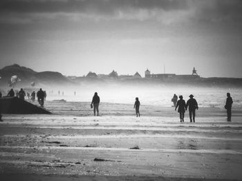 People at beach against sky