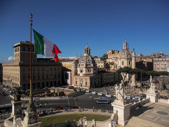 View of flags in city against clear blue sky