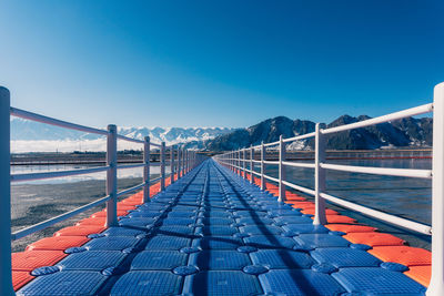 Bridge over sea against clear blue sky