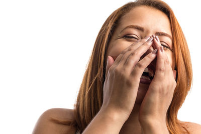 Portrait of woman covering face against white background