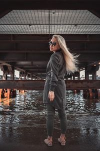 Full length portrait of young woman standing in water