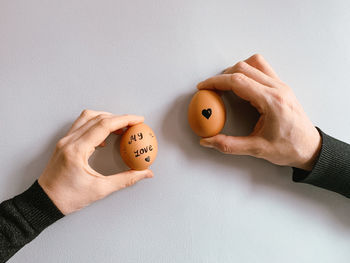 Cropped hand of man holding apple