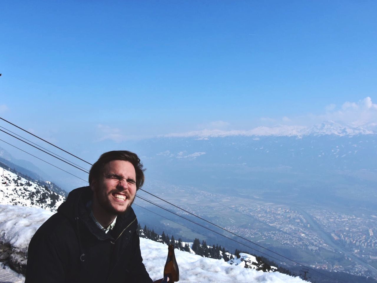 Man making face by landscape against sky