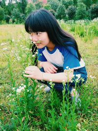 Portrait of young man sitting on grassy field