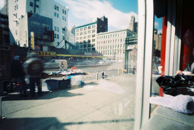 People on street amidst buildings in city