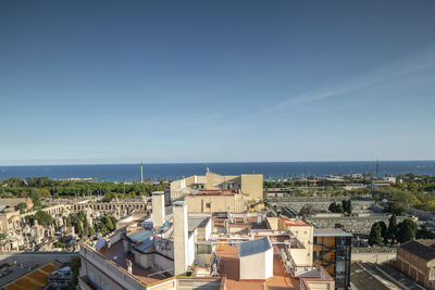 High angle view of buildings and sea against clear sky