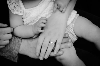 Midsection of baby girl sitting on mother lap