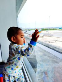 Portrait of boy looking through window