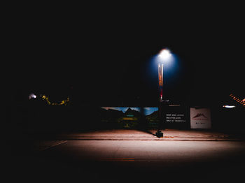 Illuminated street lights on road in city at night