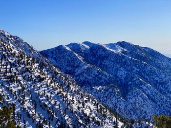 Scenic view of snowcapped mountains against clear blue sky