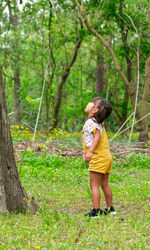 Full length of girl starring at tree 