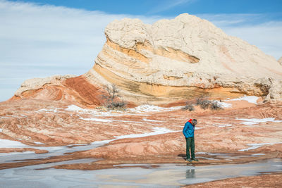 Full length of man standing on rock against sky