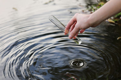 Person holding fish in lake