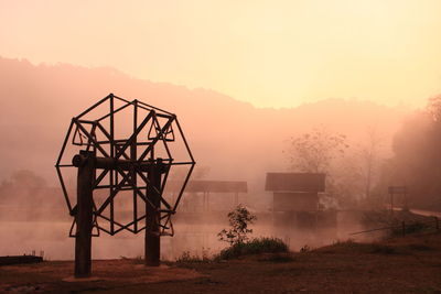 Cranes against sky during foggy weather