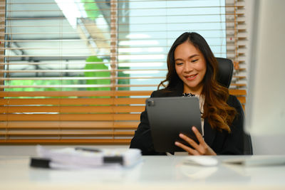 Portrait of young woman using digital tablet at home