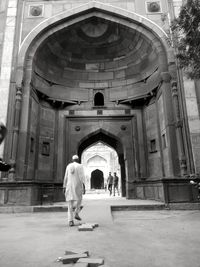 Rear view of people walking in front of building