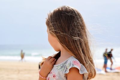 Midsection of woman at beach against sky