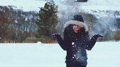 Woman standing on snow covered tree