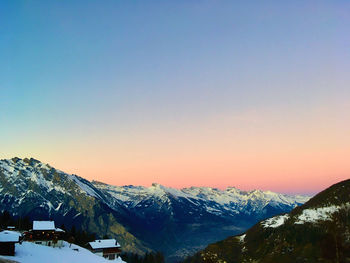 Scenic view of snowcapped mountains against sunset sky in switzerland 