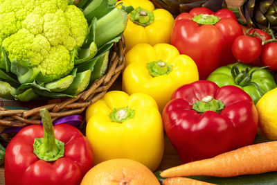 Yellow and red peppers with cauliflower on a brown wooden table