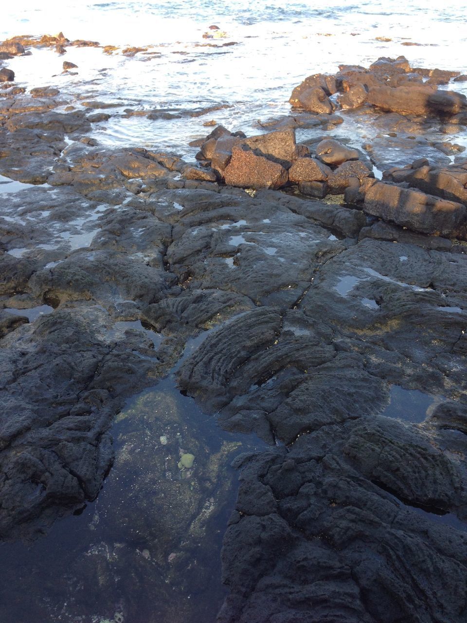 HIGH ANGLE VIEW OF ROCK FORMATION ON SEA SHORE