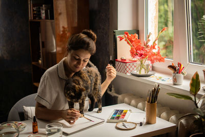 Woman sitting on table at home