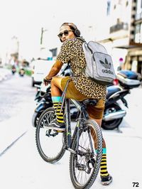 Man riding bicycle on street in city