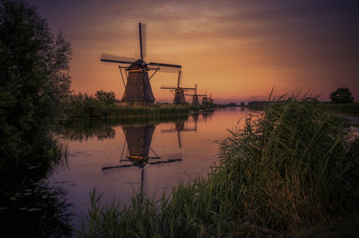 Silhouette of traditional windmill against sky during sunset