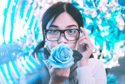 Portrait of smiling young woman holding eyeglasses