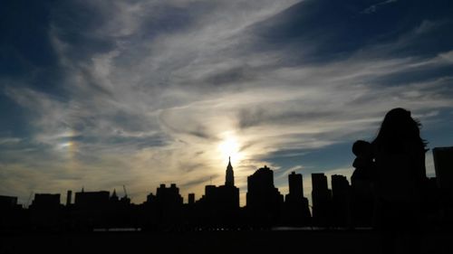 Silhouette of buildings against cloudy sky