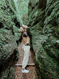 Woman standing on rock against trees