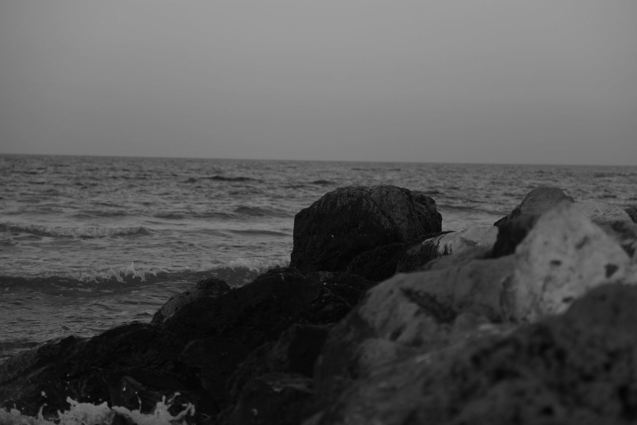 ROCKS ON BEACH AGAINST SKY