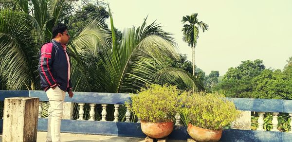 Man standing by plants against sky
