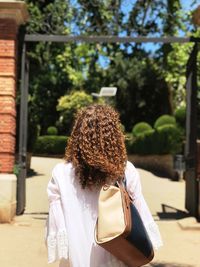 Rear view of woman standing against trees