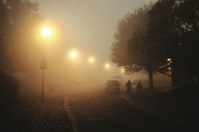 Illuminated street light against sky at night