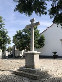Cross in cemetery against trees